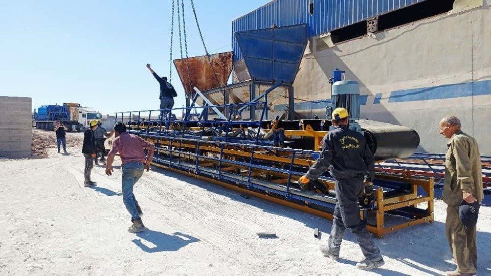 Workers installing conveyor belt equipment